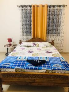 a bedroom with a bed with a blue and white blanket at Fourseason frankcottage in Chikmagalūr