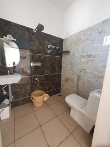 La salle de bains est pourvue de toilettes et d'un lavabo. dans l'établissement Fourseason frankcottage, à Chikmagalur