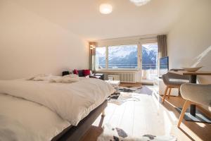 a bedroom with a bed and a desk and a window at Fortuna 1 in Arosa