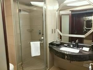 een badkamer met een wastafel en een glazen douche bij Hengna International Hotel in Yiwu