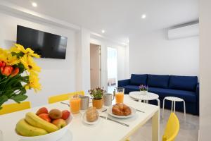 una mesa con un bol de fruta y zumo de naranja en New 2 bedroom beach and city center - Ruiz Vertedor by 10ToSea, en Fuengirola