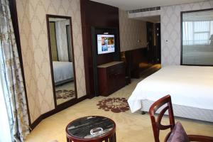 a bedroom with a bed and a large mirror at Hengna International Hotel in Yiwu