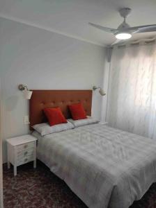 - une chambre avec un grand lit et 2 oreillers rouges dans l'établissement Tropicana Park, à Gandía