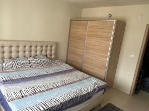 1 dormitorio con 1 cama y armario de madera en Anton Apartment, en Kočani