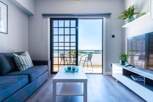 een woonkamer met een bank en een tafel bij Peale's 2-Bedroom Apartment in Mackenzie in Larnaka
