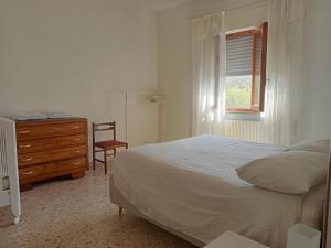 een slaapkamer met een bed, een dressoir en een raam bij Casa del Nonno in Pietrasanta