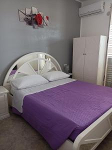 una camera da letto con un grande letto con lenzuola viola di Vacanze in Sicilia a Siculiana