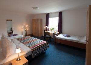 a hotel room with two beds and a desk at Hotel König in Remscheid
