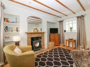 a living room with a fireplace and a chair at Dunira in Cupar