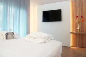 sypialnia z łóżkiem z białymi ręcznikami w obiekcie Toscana Charme Resort w mieście Tirrenia