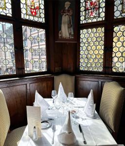 un comedor con una mesa con gafas y ventanas en Maison Kammerzell - Hotel & Restaurant, en Estrasburgo