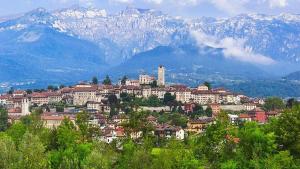 uma cidade numa colina com montanhas ao fundo em La Mansarda em Feltre
