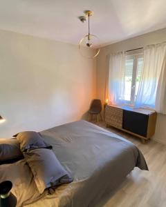 a bedroom with a large bed and a window at Appart'Hôtel Sous Les Pins in Martigues