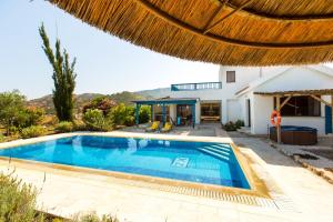 a villa with a swimming pool and a house at Villa Med. Coast in Argaka
