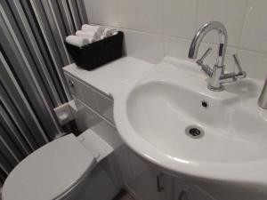 a white bathroom with a sink and a toilet at The Claremont in Woodhall Spa