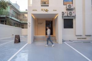 a woman walking into a building at Anook Hotel Guri in Guri