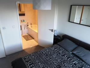 a bedroom with a bed and a bathroom with a tub at 3 Bed - Modern, High Spec, Spacious Apartment in London