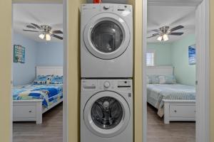 um quarto com uma máquina de lavar roupa e uma cama em Boardwalk Shores C Duplex em Atlantic Beach