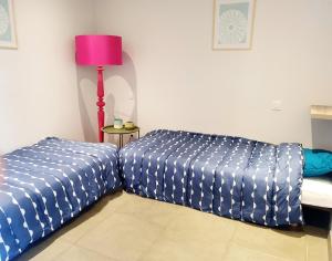 Habitación con cama y mesa con lámpara. en Appartement plein pied climatisé dans maison catalane, en Bompas