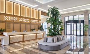 a lobby with a palm tree in the middle of it at Meliá Durrës Albania in Durrës