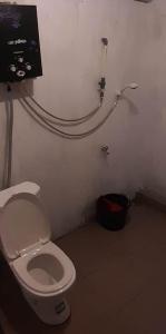 a bathroom with a toilet and a tv on the wall at Cabin LEHA LEHE SYARIAH Dieng in Diyeng