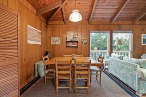 comedor con mesa, sillas y sofá en Dogwood Treehouse home, en Pine Knoll Shores