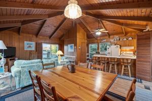 comedor y sala de estar con mesa de madera en Dogwood Treehouse home, en Pine Knoll Shores