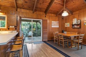cocina y comedor con mesa y sillas en Dogwood Treehouse home, en Pine Knoll Shores
