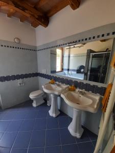 a bathroom with two sinks and a toilet and a mirror at B&B Harem in Arcidosso