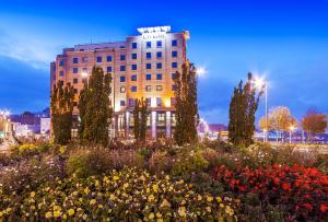 a building with a flower garden in front of it at City Hotel in Derry Londonderry