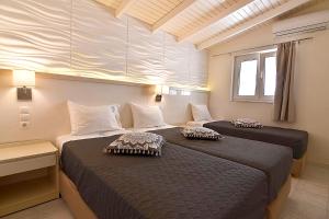 um quarto com duas camas num quarto em Alonia Hotel em Kalamaki