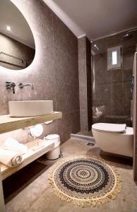 een badkamer met een wastafel, een toilet en een bad bij Alonia Hotel in Kalamaki