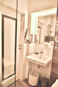 La salle de bains blanche est pourvue d'un lavabo et d'un miroir. dans l'établissement Apartament KonDor Shekspir, à Gdańsk