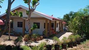 a house with trees and plants in front of it at Casa James Apartment, Rooms , Pool and Restaurant in Siquijor
