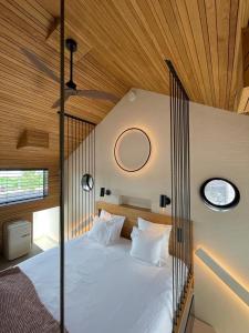 Cama grande en habitación con techo de madera en vondice hotel en Ámsterdam