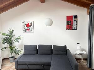 a living room with a couch and a plant at Casa Cleopatra in Bergamo