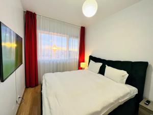 sypialnia z białym łóżkiem i czerwonymi zasłonami w obiekcie Red Hotel Accommodation w Klużu-Napoce