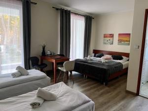 una camera d'albergo con 2 letti, scrivania di Polana Łukęcin - Pobierowo a Łukęcin