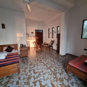 a living room with a bed and a table and chairs at Dhammika Beach Palace in Wadduwa