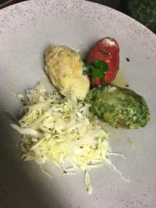 a plate of food with cabbage and cheese on it at Tlisöra Speckstube in Frena