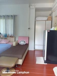 - une chambre avec un lit et une télévision dans l'établissement Min Home, à Lamphun