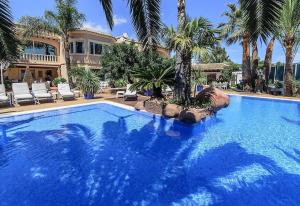 een groot zwembad met palmbomen en een huis bij Luxury Xenofilia lll in Moraira