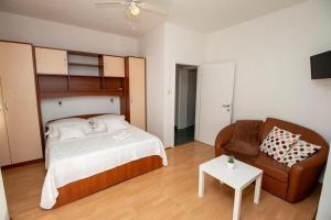 a bedroom with a bed and a couch and a table at Apartments by the sea Duce, Omis - 7576 in Duće