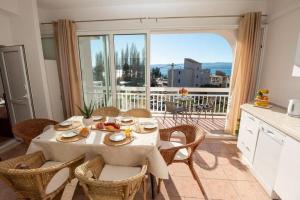 a dining room with a table and chairs and a balcony at Apartments by the sea Duce, Omis - 7576 in Duće