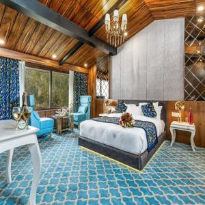 1 dormitorio con 1 cama, mesa y sillas en Hotel SnowLand, Srinagar en Srinagar