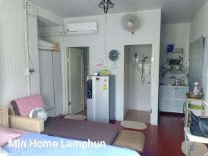 a small room with a refrigerator and a kitchen at Min Home in Lamphun