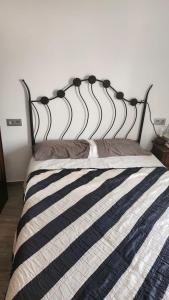 een bed met een zwart-wit gestreept dekbed bij Maestranza in Berja