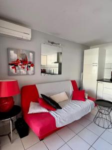 ein rot-weißes Sofa im Wohnzimmer in der Unterkunft 4 PERS, 1 CHAMBRE, PLAGES ET COMMERCES A PIED in Sète