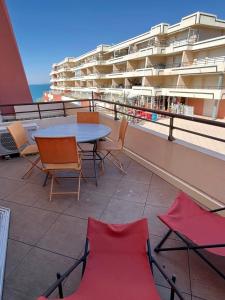 einen Tisch und Stühle auf einem Balkon mit einem Gebäude in der Unterkunft 4 PERS, 1 CHAMBRE, PLAGES ET COMMERCES A PIED in Sète