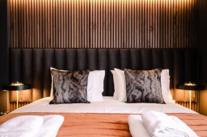 a bedroom with a large bed with a black headboard at Sweeney Rooms Aviemore in Aviemore